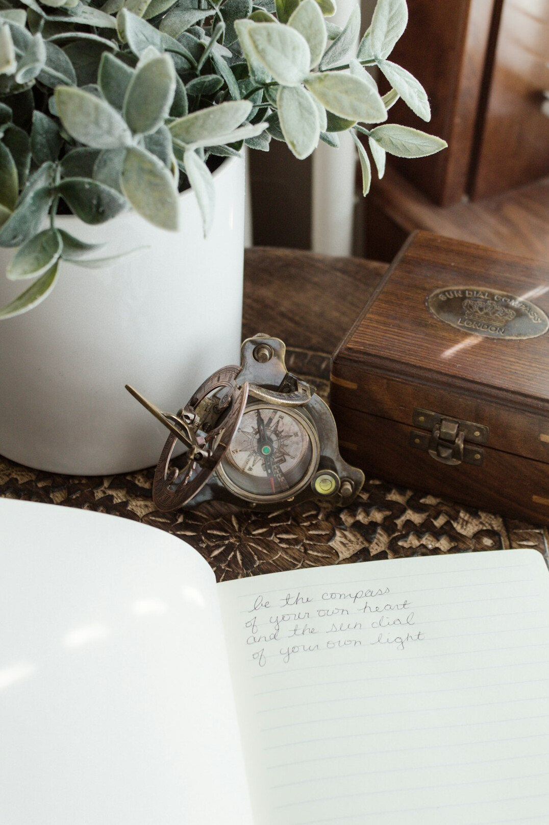 Close up of handwritten notes in a notebook next to a plant