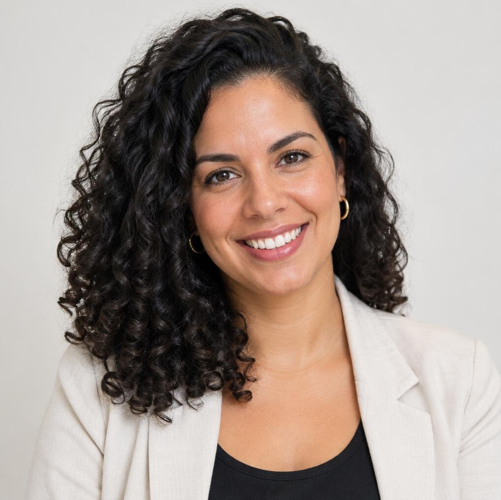 Studio portrait of a Brazilian woman with curly hair smiling