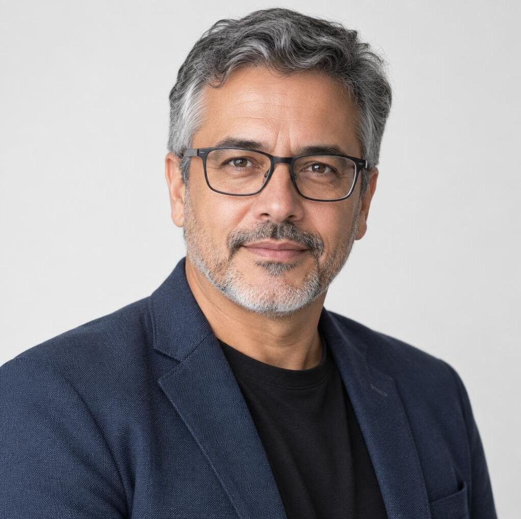 Studio portrait of an older Brazilian man with glasses